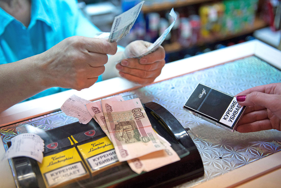 продавец продает сигареты на кассе